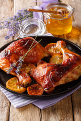 Fresh fried chicken leg with lavender honey, spices and lemon close-up on a plate. vertical