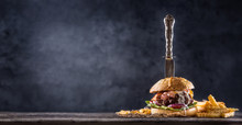 Close-up Home Made Beef Burger With Knife And Fries On Wooden Table