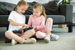 © LIGHTFIELD STUDIOS - little sisters with gamepads playing video game together at home