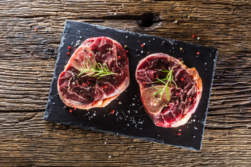 Wall Mural - Two pieces raw beef shank on slate board and wooden table.