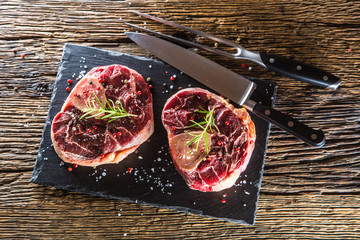 Wall Mural - Two pieces raw beef shank on slate board and wooden table.