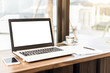 © Thinapob - Mockup image of laptop with blank white screen,smartphone,coffee cup on wooden table of In the coffee shop.