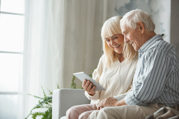 Wall Mural - Senior couple together at home retirement concept using digital tablet