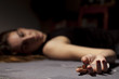 a drugged girl lying on the floor with a syringe in her hand