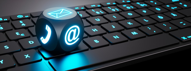 Leuchtender Würfel mit Kommunikations-Symbolen auf Tastatur