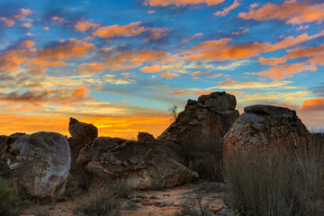 Big dramatic rocks in the Kagga Kamma Reserve at sunrise with orange clouds and blue sky