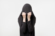Woman hiding face under the clothes. She is oulling sweatr on her head. Depressed emotion.