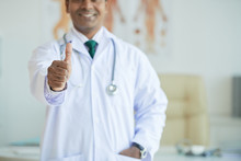 Portrait Of Medical Doctor Smiling And Giving Thumb Up At Office