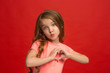 © master1305 - The happy teen girl standing and smiling against red background.