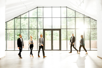 Wall Mural - Business people at the spacious modern hall with big window overlooking on the park. Wide view with copy space