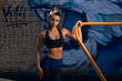 © Dmitry Tsvetkov - Young beautiful sporty athlete woman with pony tail brunette hair in blue leggings and black top standing at outdoor workout gym. Portrait of sexy girl at sunset