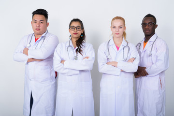 Wall Mural - Studio shot of diverse group of multi ethnic doctors standing wi