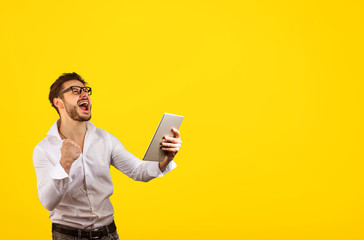 Happy man celebrating win on tablet