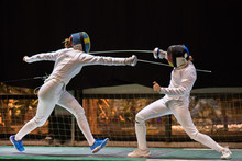 Two Woman Fencing Athletes Fight