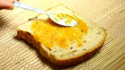 Wall Mural - Spreading  orange jam on bread