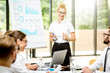 © rh2010 - Young woman speaker reporting with flip chart during a conference with business people in the beautiful office on the green background