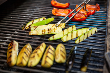 delicious vegetables grilling in open grill, outdoor kitchen. food festival in city. tasty food peppers zucchini roasting on basket, food-court