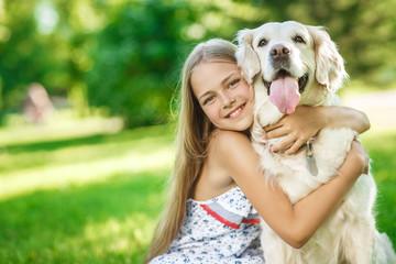 Little girl with golden retriever dog in the park