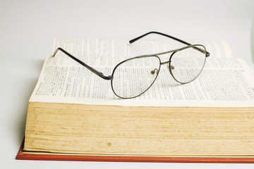 Glasses on open book with white background