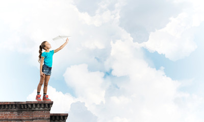 Concept of careless happy childhood with girl dreaming to become pilot