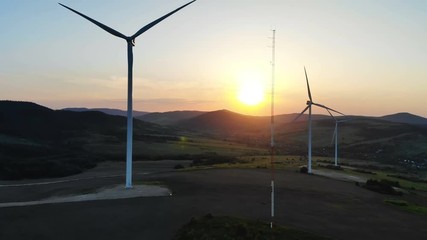 Wall Mural - aerial view of modern windmill farm on summer sunset over the mountains scenic landscape wind turbines in motion ecologically friendly clear rural area freshness future technology healthy lifestyle