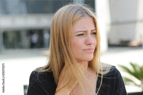 Foto Junge Frau mit Halsschmerzen draußen im Sommer