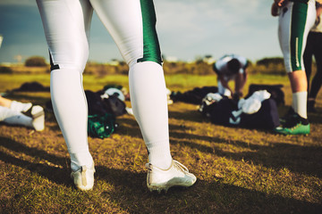 Wall Mural - Closeup of football players on a field with their equipment