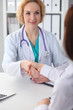 © rogerphoto - Doctor and patient shaking hands, close-up. Medicine, healthcare and trust concept