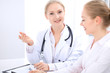 © rogerphoto - Blonde female doctor and patient talking in hospital office. Health care and client service in medicine