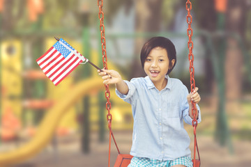 Little girl holds American flag in the playground