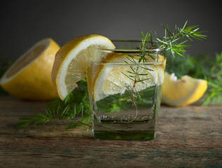 Blue gin , tonic and lemon slices on a old wooden table.