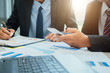 © A Stockphoto - Business people partner negotiating a contract, they are pointing on a document and discussing together,Two businessmen are negotiating in office.