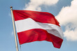 © rustamank - Flag of Austria waving in the wind on flagpole against the sky with clouds on sunny day, close-up