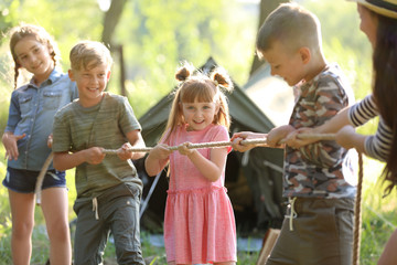 Wall Mural - little children pulling rope outdoors. summer camp