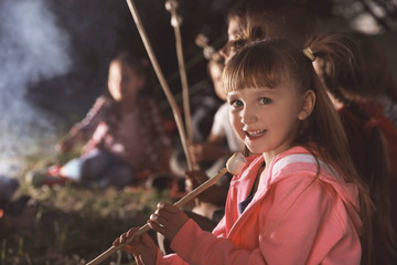 Wall Mural - little girl with marshmallow near bonfire at night. summer camp