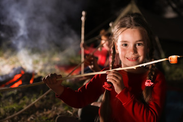 Poster - Adorable little girl with roasted marshmallow near bonfire at night. Summer camp