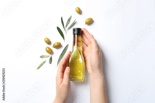 Dekoracja na wymiar  kobieta-trzyma-butelke-z-oliwa-i-dojrzalymi-oliwkami-na-bialym-tle