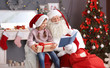© New Africa - Authentic Santa Claus reading book to little girl indoors