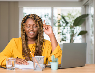 Poster - African american woman studying with laptop surprised with an idea or question pointing finger with happy face, number one