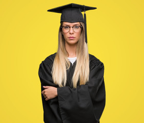 Wall Mural - Beautiful young woman wearing glasses and graduation robe with a confident expression on smart face thinking serious