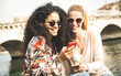 © Mirko Vitali - Happy multiracial girlfriends having fun outdoors with mobile smart phone - Friendship concept with girls at spring break travel - Modern female lifestyle with women best friends - Bright filter tone