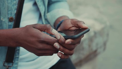 Close up hands young African American man uses the phone and smartwatch at the street business shopping internet face technology call texting mobile smart attractive cell communication slow motion