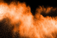 Abstract Explosion Of Orange Dust. Abstract Orange  Powder Splatter On Black  Background. Freeze Motion Of Orange  Powder Splash.
