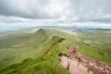 People hiking on the hillside of Pan Y Fan in Brecon Beacons, Wales