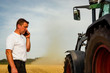 Getreideernte - Organisation, Landwirt telefoniert auf dem Feld