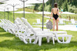 © rh2010 - Young woman in black swimsuit standing with cocktail at the swimming pool area during summer vacations