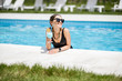 © rh2010 - Portrait of a beautiful woman in black swimsuit relaxing with cocktail at the swimming pool outdoors