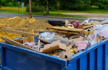 Wall Mural - Blue construction debris container filled with rock and concrete rubble. Industrial garbage bin