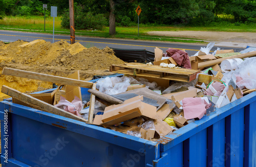 Fotografía Blue construction debris container filled with rock and concrete rubble