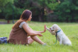 © lordn - Beautiful young girl playing with a puppy Labrador in the park
